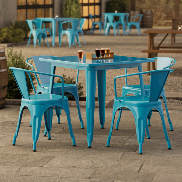 A turquoise Lancaster Table & Seating table with four chairs on a patio.