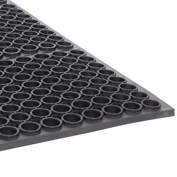 A close-up of a black rubber Cactus Mat with holes in it.