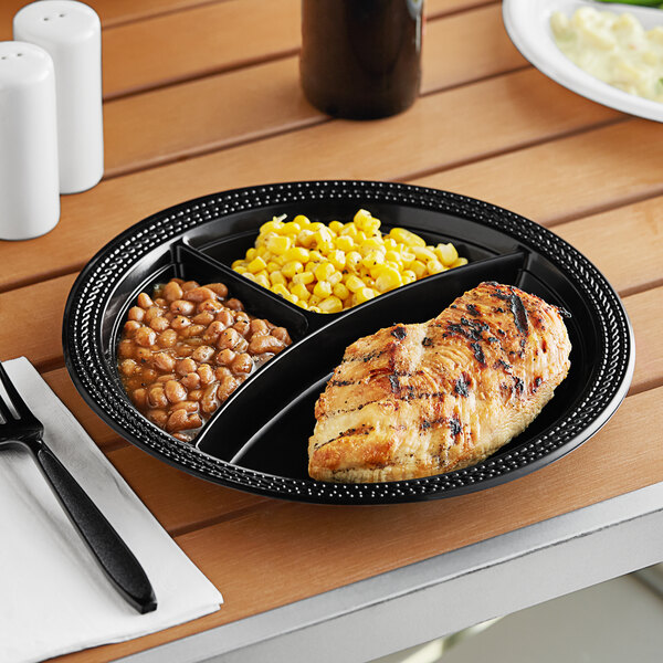 A Fineline black polypropylene plate with chicken, corn and beans on it.