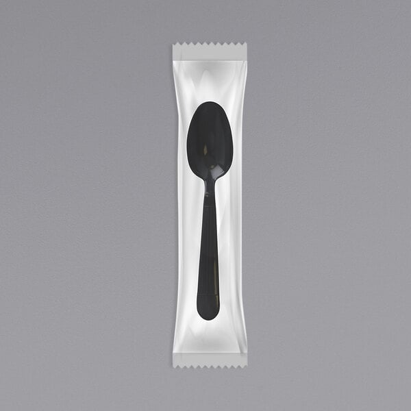 An individually wrapped black plastic spoon.