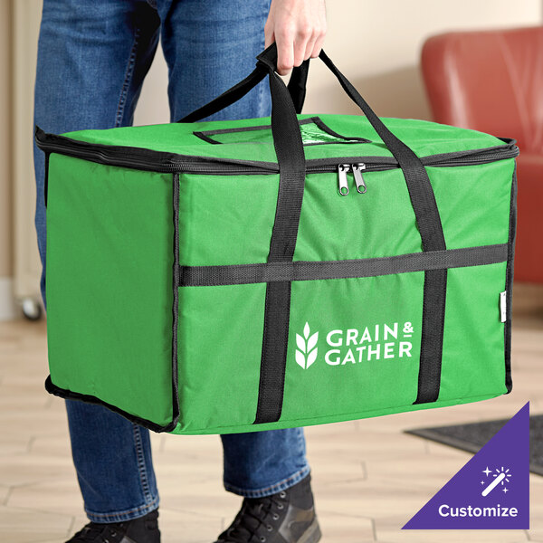 A person holding a green Choice insulated food delivery bag with black straps.