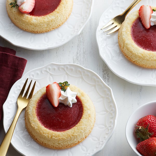 A dessert pastry with Les Vergers Boiron Strawberry puree on a white plate with a gold fork.