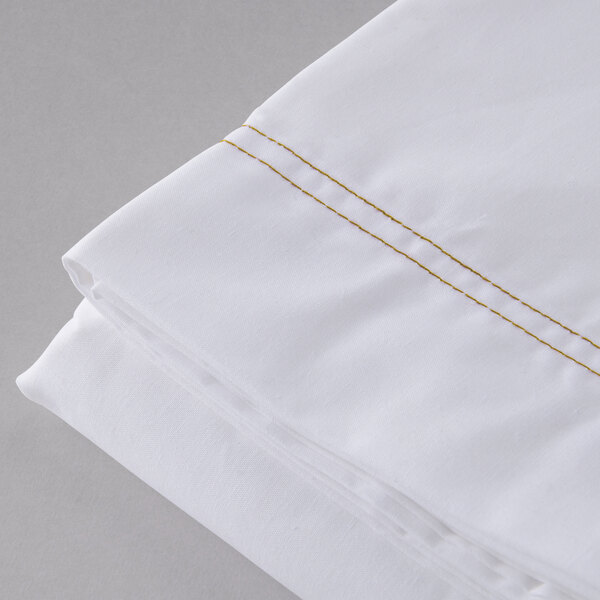 A close up of a white Oxford Superblend microfiber flat sheet with gold stitching.