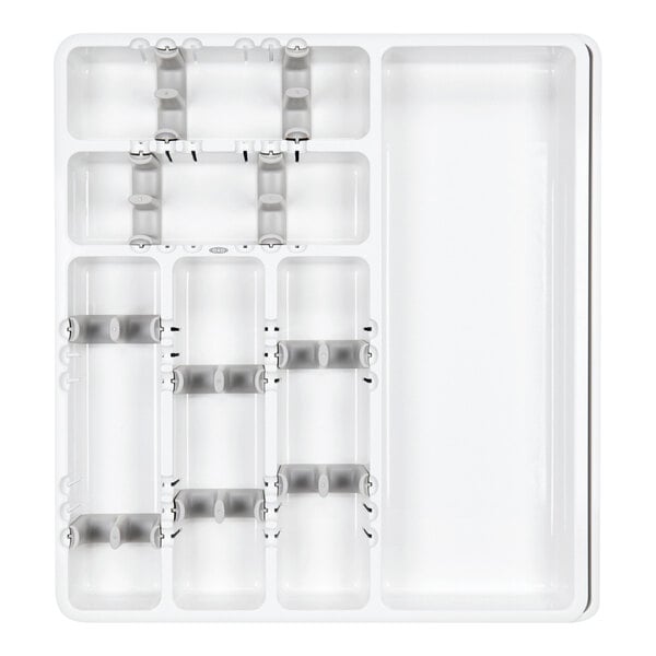 A white plastic tray with multiple compartments and adjustable dividers, designed for organizing utensils.