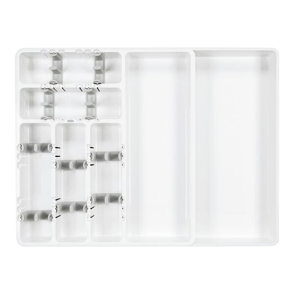 A white plastic tray with multiple compartments and adjustable dividers, designed for organizing utensils.