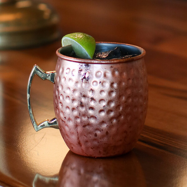 An Arcoroc copper Moscow Mule mug with a lime wedge in it.