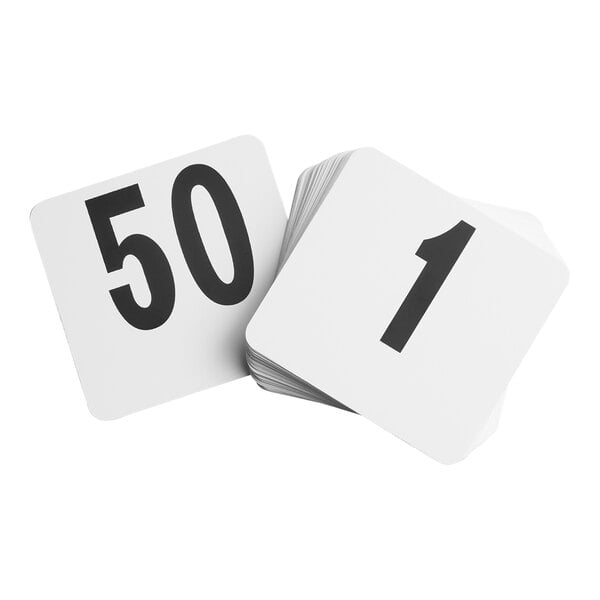 A stack of white square cards with large black numbers, showing the numbers 1 and 50 on top.