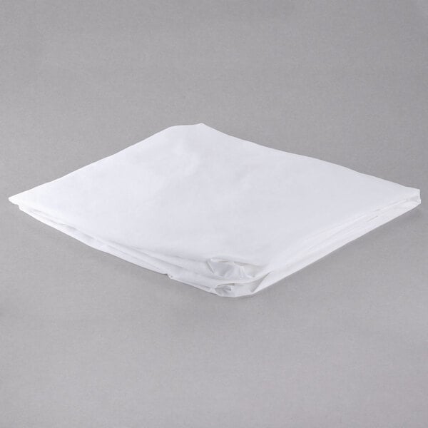 A folded white sheet on a gray surface.