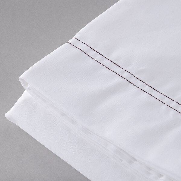 A white Oxford Superblend queen size flat sheet with brown stitching.