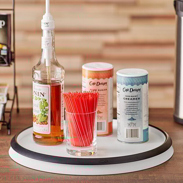An OXO Good Grips Lazy Susan with a bottle of alcohol and a bottle of soda on it.