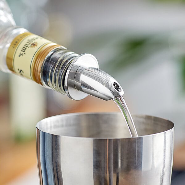 A person using a Choice chrome liquor pourer to pour liquid into a cup.