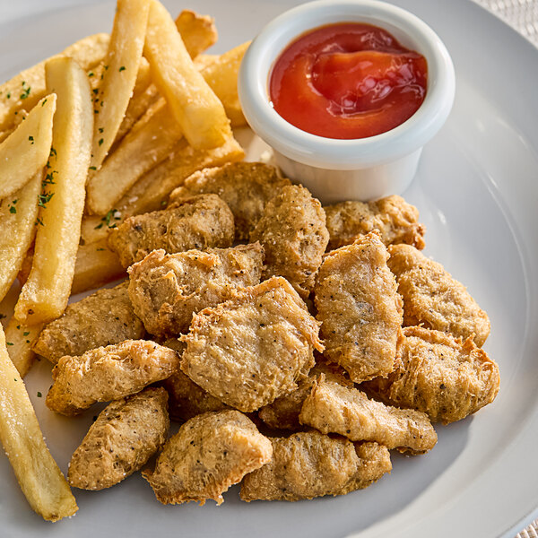 A plate of Beleaf Plant-Based Vegan Chicken Nuggets and french fries with a bowl of ketchup.
