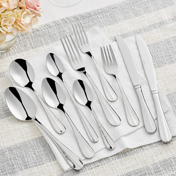 An Acopa stainless steel dinner spoon on a white surface.