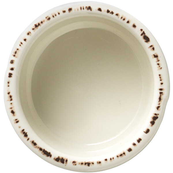 A Libbey Farmhouse ivory melamine sauce cup with brown spots.