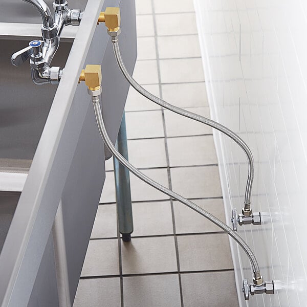 A wall mounted Regency faucet with a swing spout above a sink with pipes connected to it.