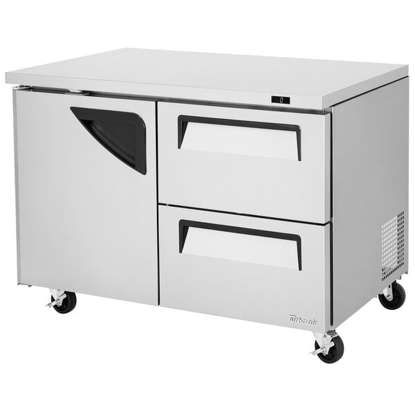 A stainless steel Turbo Air undercounter freezer with one door and two drawers.