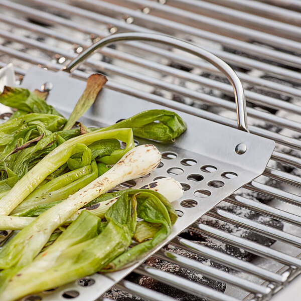 A stainless steel Outset grill tray with green vegetables on it.