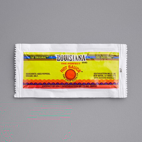 A yellow and red packet of The Original Louisiana Brand Hot Sauce.