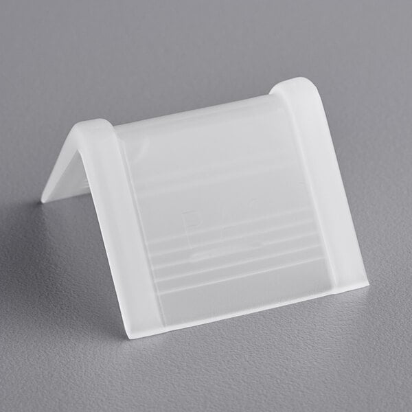 A PAC Strapping Products white plastic edge protector on a gray surface.