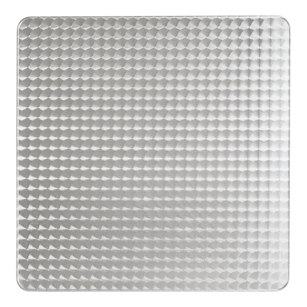 A close-up of a white square metal table top with a pattern of dots.