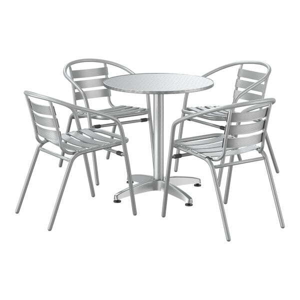 A white metal table with a white surface and four silver arm chairs.