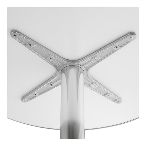 A white Lancaster Table & Seating outdoor table with a metal base.