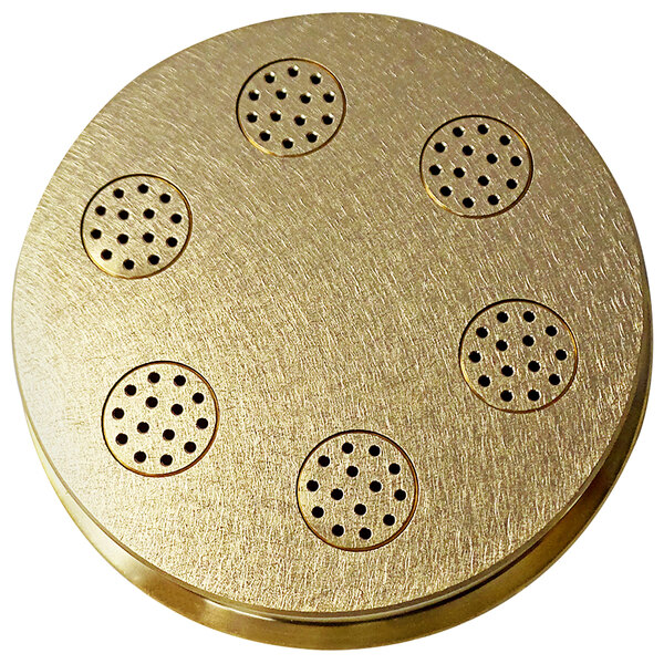 a circular gold object with holes