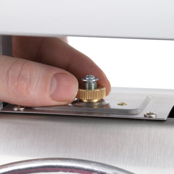 A person using an Edlund heavy-duty portion scale to weigh a metal screw.