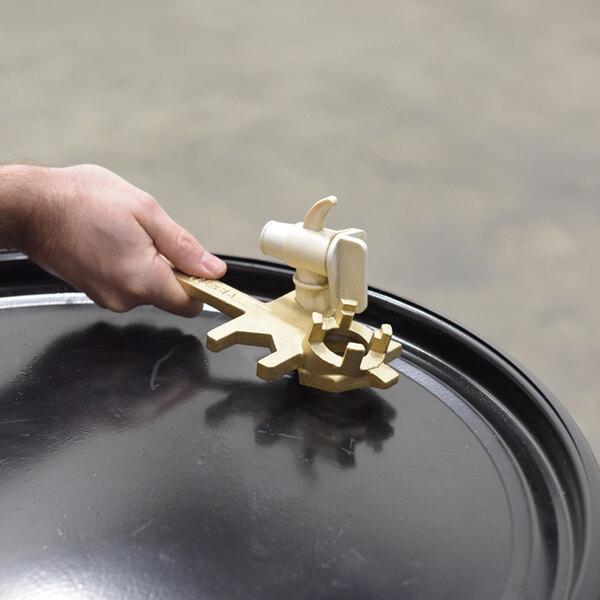 A non-sparking bronze alloy drum bung nut wrench with a faucet wrench being used on a drum opening.