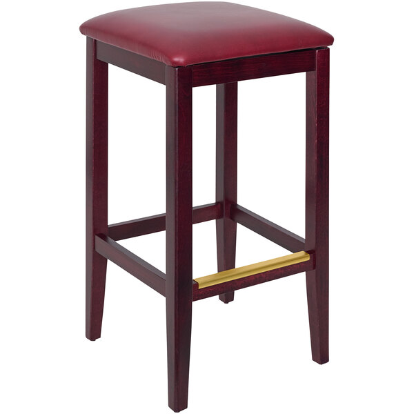 a wooden stool with a gold leg