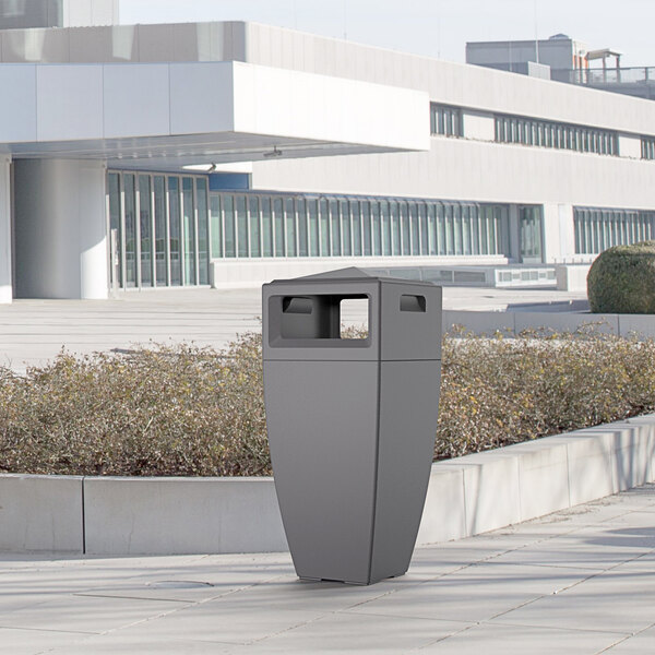 A Mayne graphite grey rectangular decorative waste bin on a sidewalk.