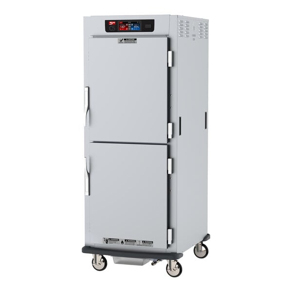 A white metal Metro C5 holding cabinet on wheels with two doors.