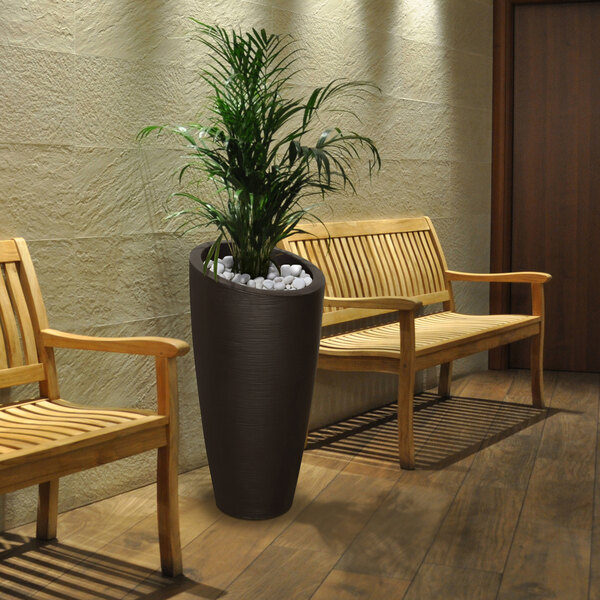 A Mayne espresso planter with a potted plant on a wooden bench.