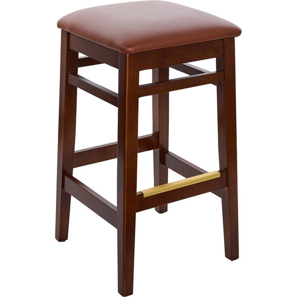 A BFM Seating dark walnut beechwood barstool with a light brown vinyl seat.