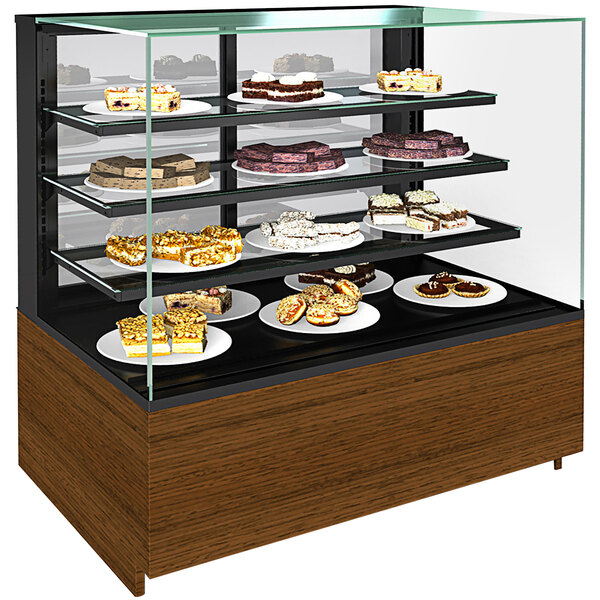 A Structural Concepts Reveal non-refrigerated bakery display case on a counter with plates of cakes and pastries on it.