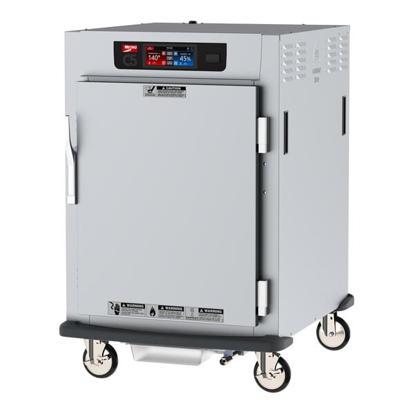 A white Metro half size holding cabinet with a solid door and wheels.