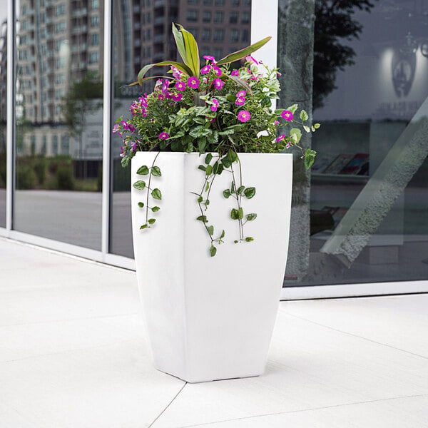 A white Mayne Kobi planter with purple flowers.