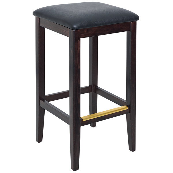 A BFM Seating dark walnut beechwood backless barstool with a black vinyl seat.