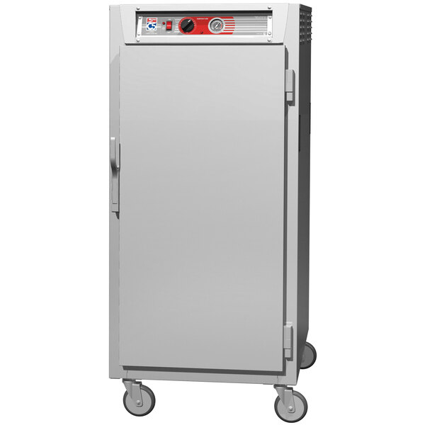 A stainless steel Metro holding cabinet with a solid door and wheels.