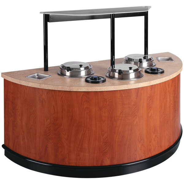 A Vollrath half round soup merchandiser cart with a wooden counter and metal frame holding two soup bowls.