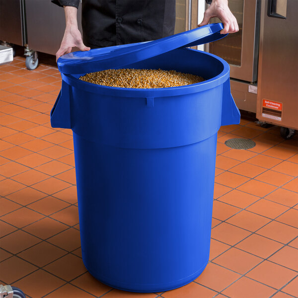 A man holding a blue Round Ingredient Storage Bin full of grains.