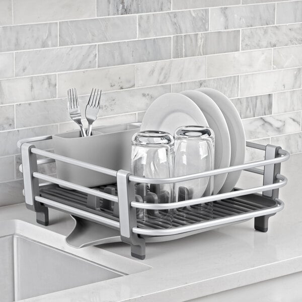 An OXO aluminum dish rack with plates and glasses on it.
