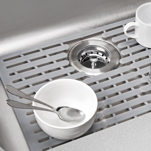 a sink with a drain and a couple of white bowls and spoons