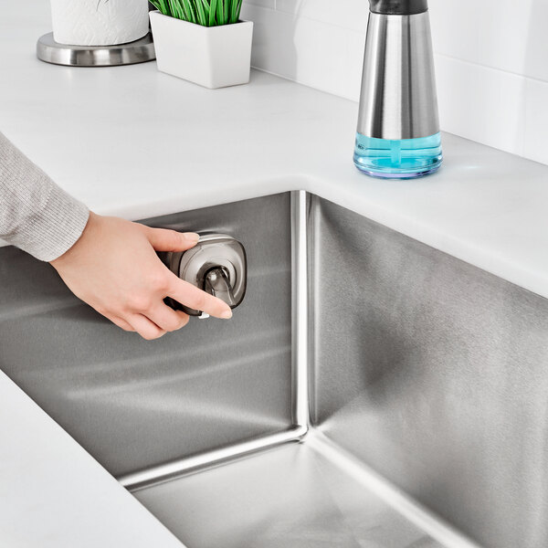 a hand pressing a key in a sink
