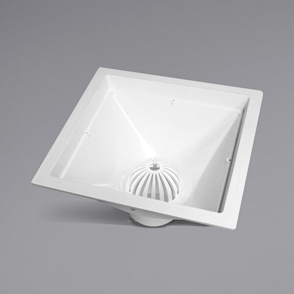 A white square floor drain with a round hole in the center.