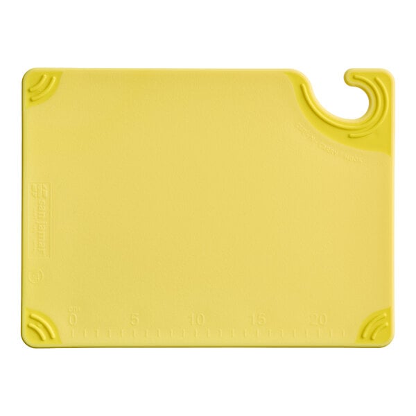 A yellow rectangular cutting board with a hook and measurement markings along one edge.