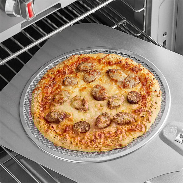 A pizza on a Choice aluminum pizza screen in an oven.