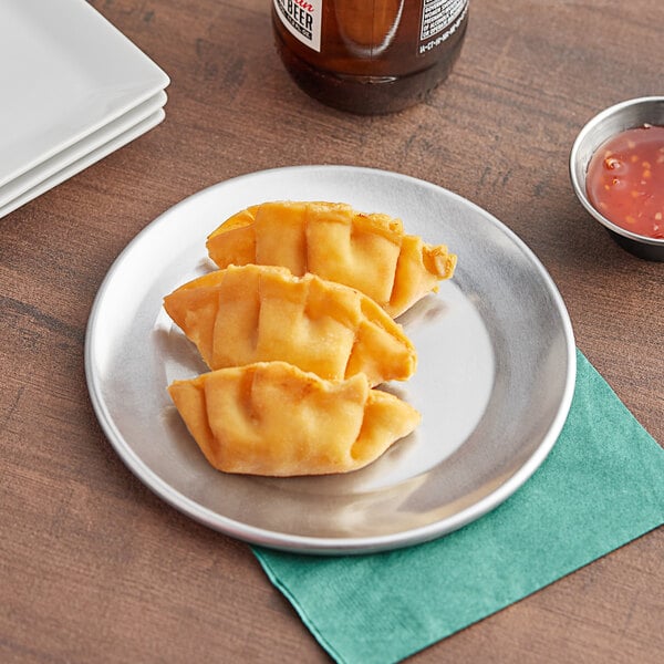 A Choice aluminum pizza pan with two slices of pizza next to a bottle of red sauce.