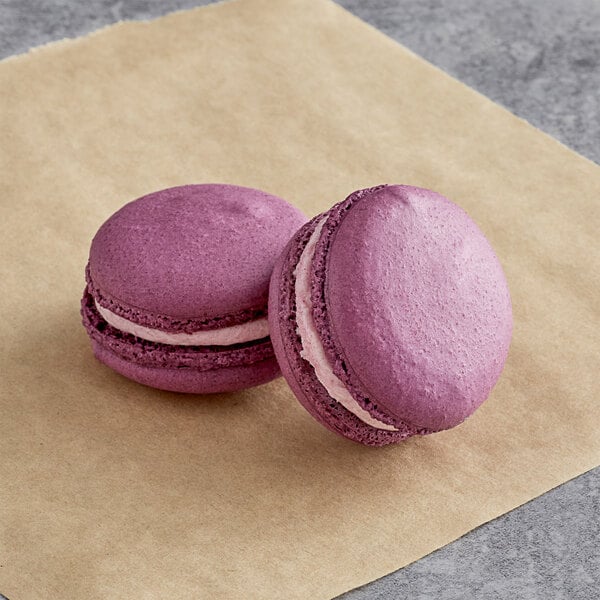 Two Ube Macarons on brown paper.