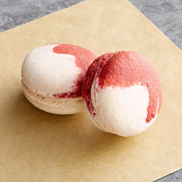 Two Macaron Centrale peppermint macarons on a brown paper.